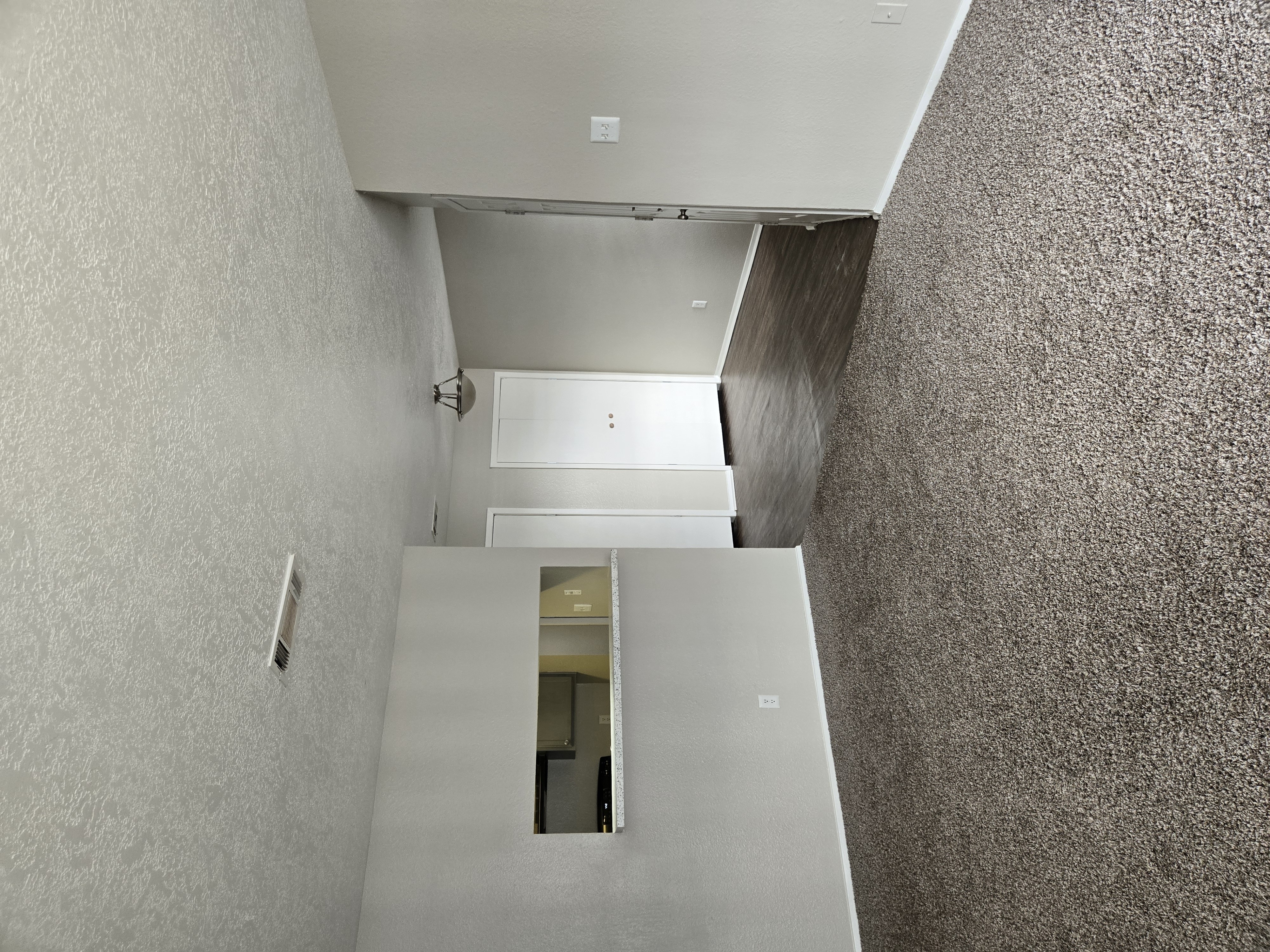 A stairwell with a grey carpeted wall and white walls.